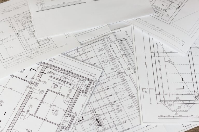 Blueprints and architectural plans scattered on a surface, showcasing detailed designs and measurements for construction projects in Bucks County.